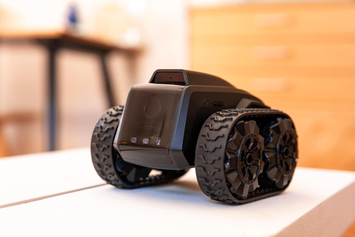 All-terrain mobile camera robot displayed on a table, showcasing its sturdy design and rugged wheels for versatile monitoring.