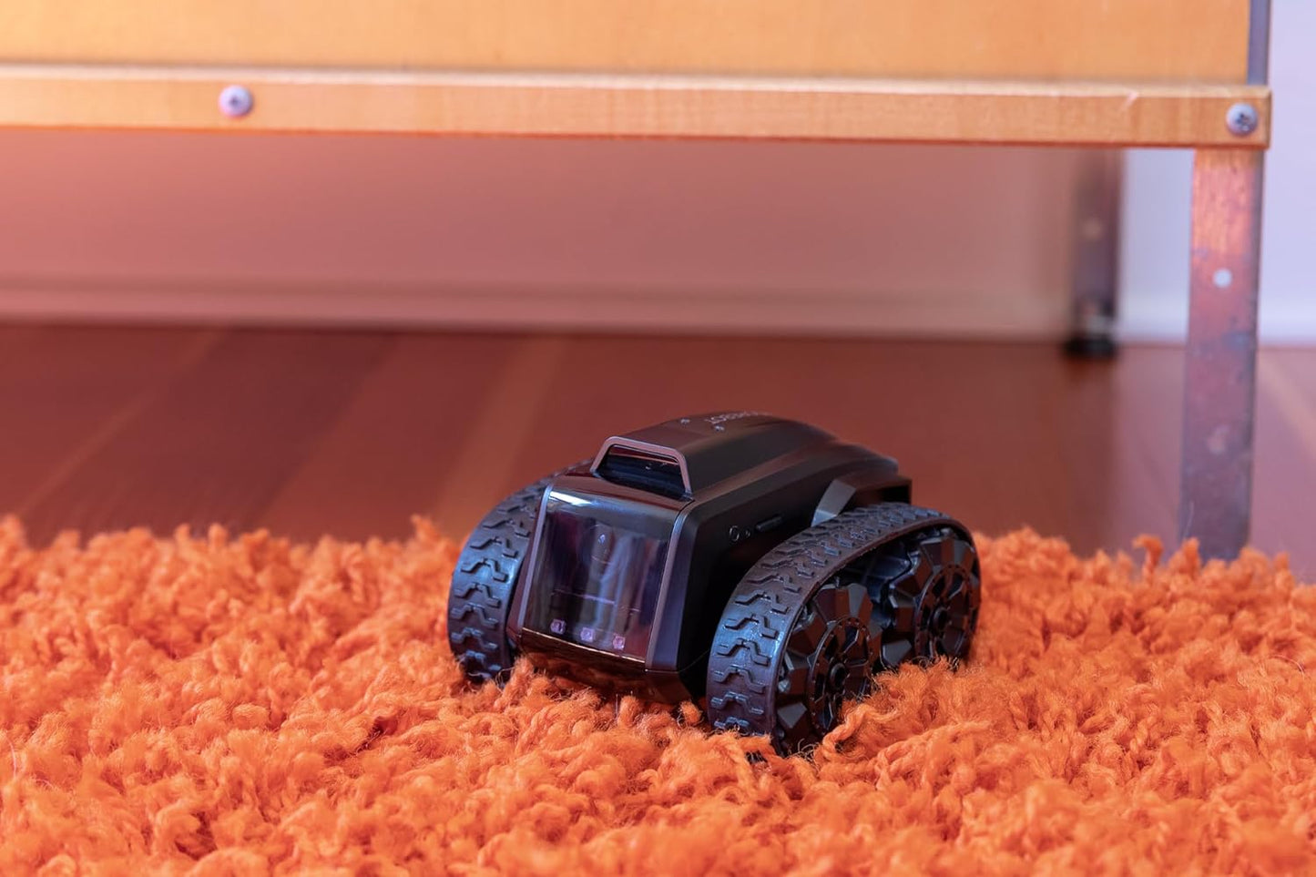 All-terrain mobile camera robot on an orange rug, designed for easy monitoring and surveillance.