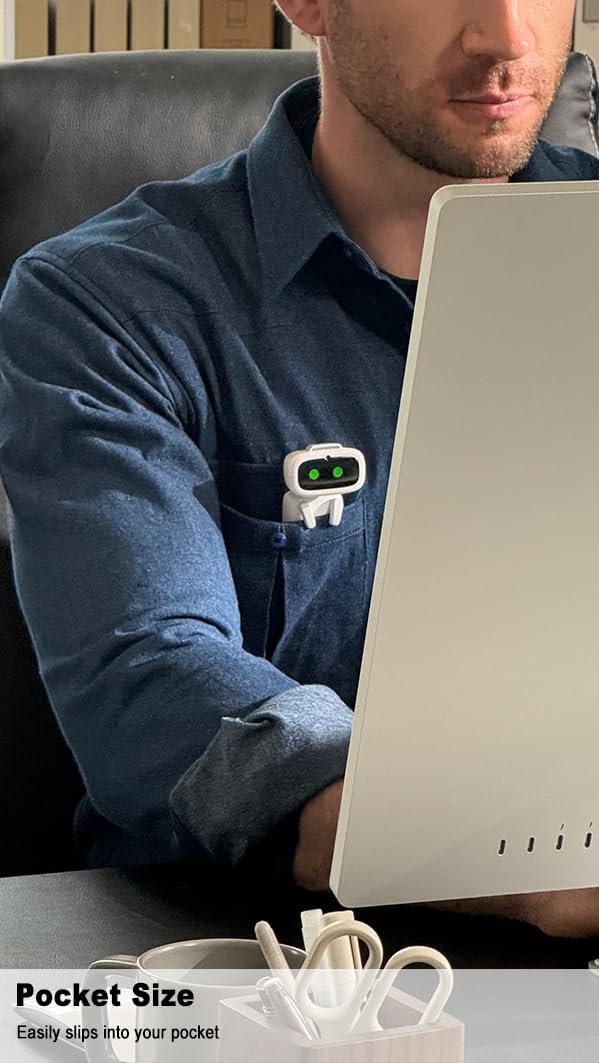 Man with ultra-portable wearable robot clipped to shirt pocket, using a computer at his desk.